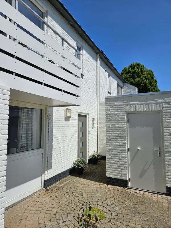 Witte gevel met grijze deuren